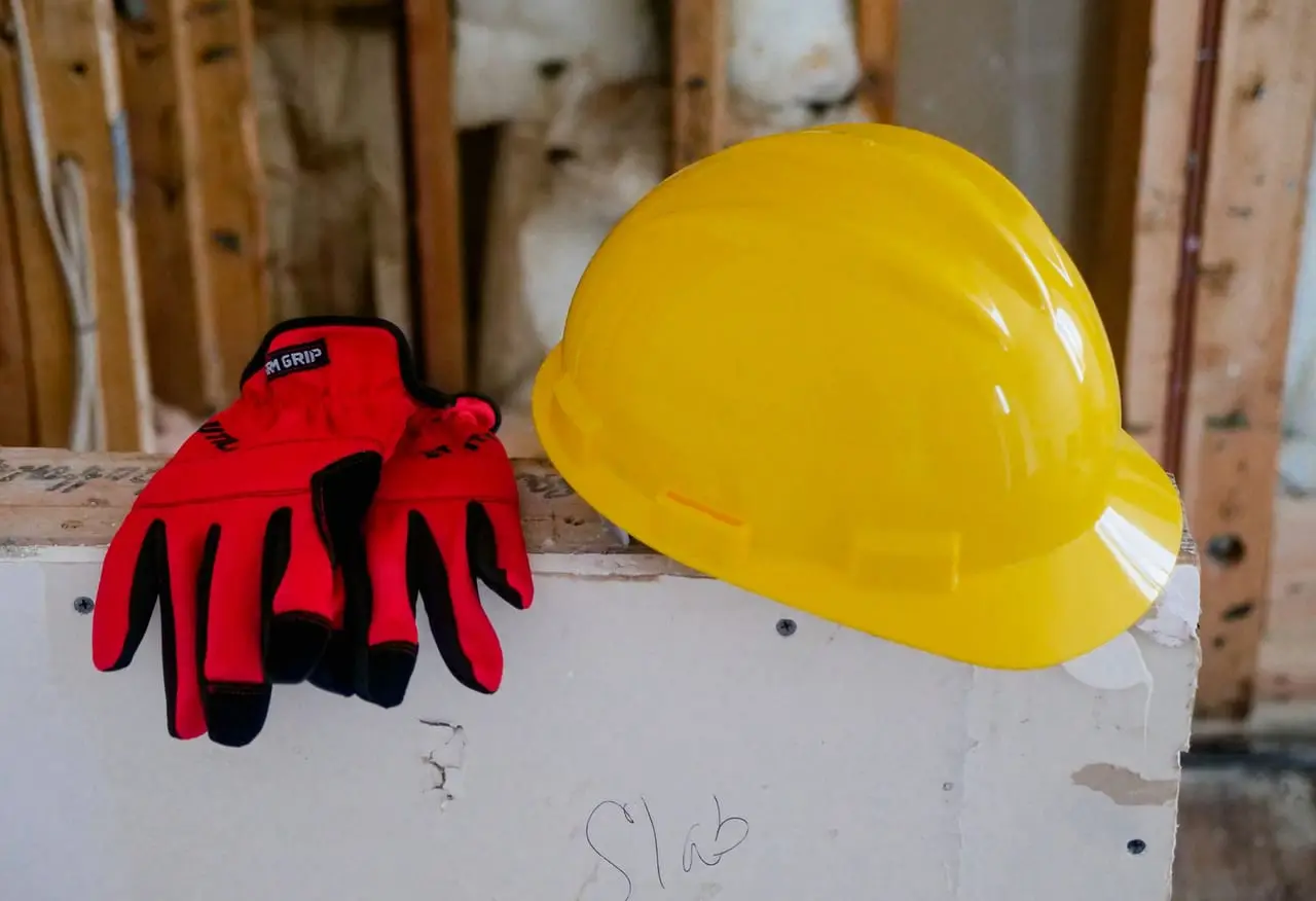 Żółty kask i czerwone rękawice robocze