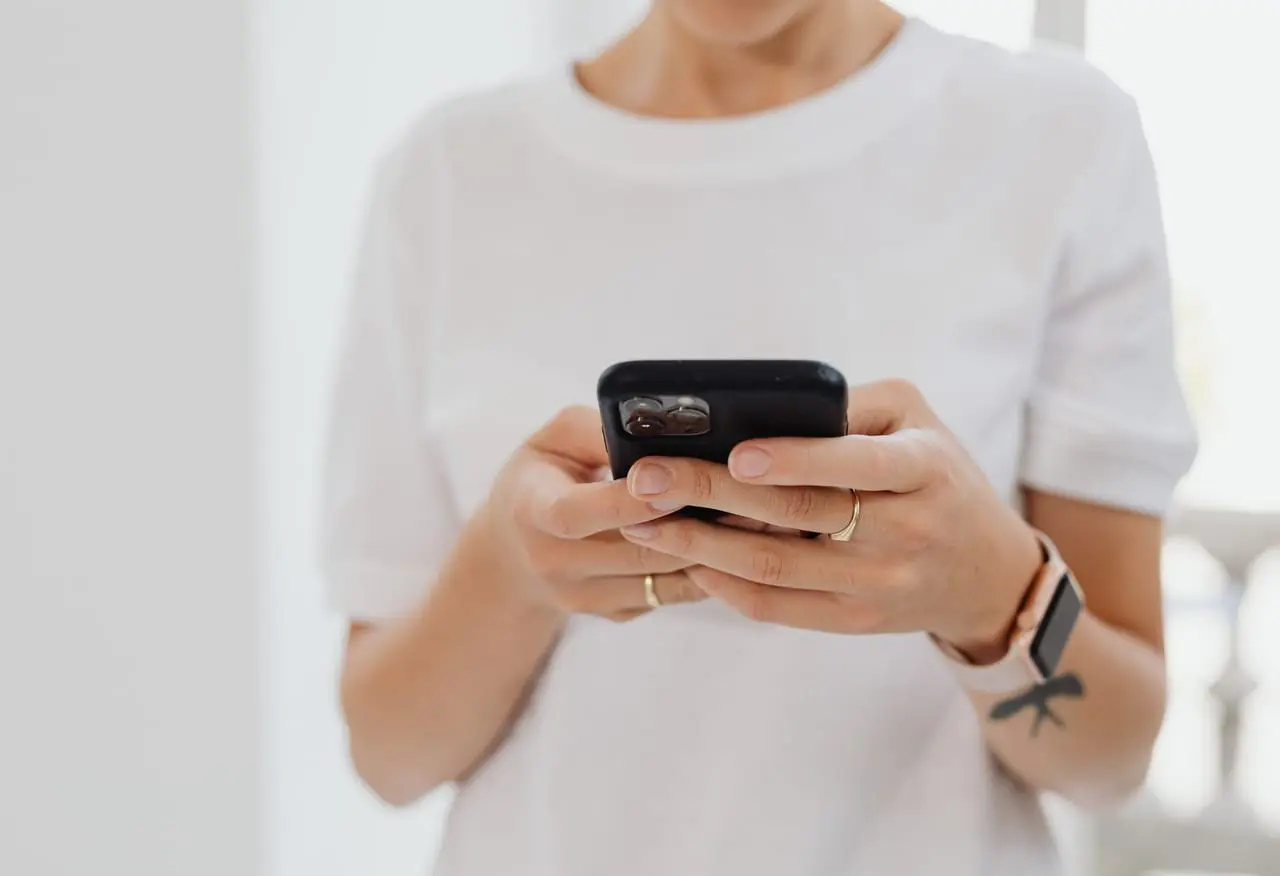 Dłonie trzymają smartfon