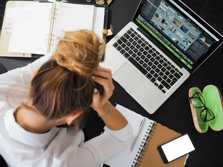 Zmartwiona kobieta przy laptopie z notatnikiem