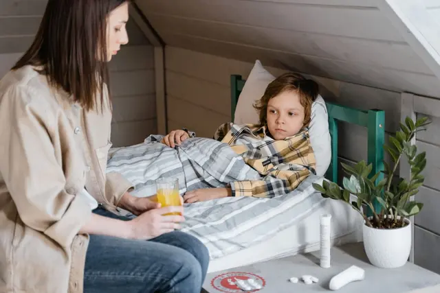 Matka siedzi przy łóżku chorego dziecka